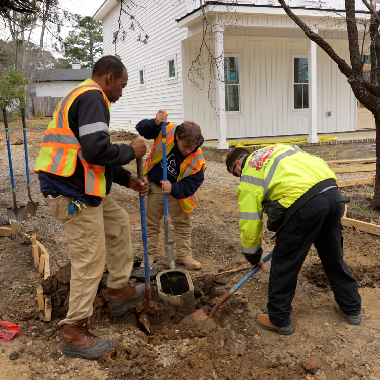 Three Town of Clayton’s Water Resources Crew members move water line under driveway