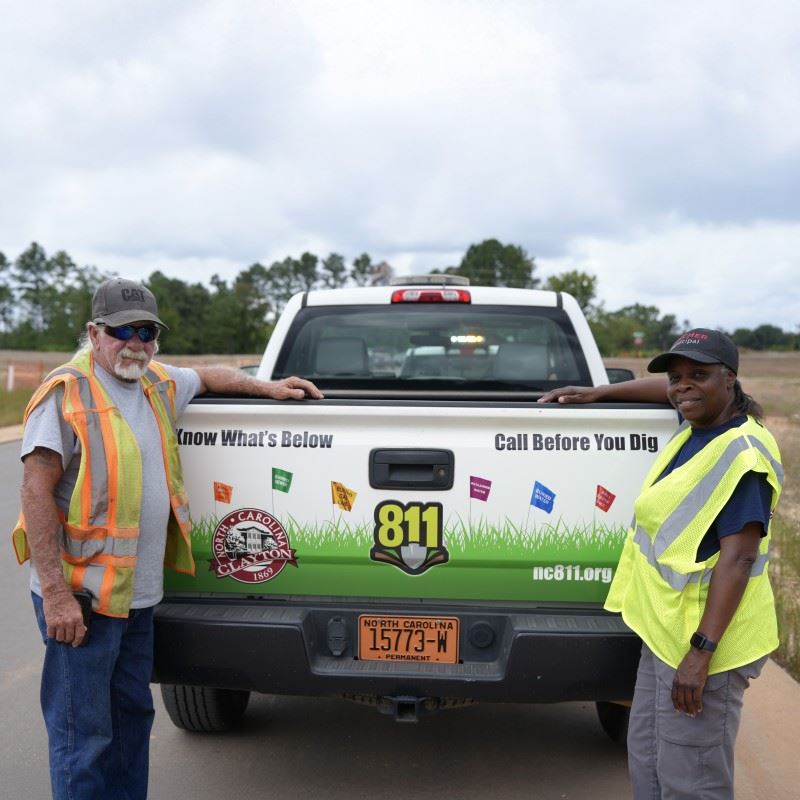 Locators Mark VanPelt and Lenetta Lucas stand behind the 811 Truck