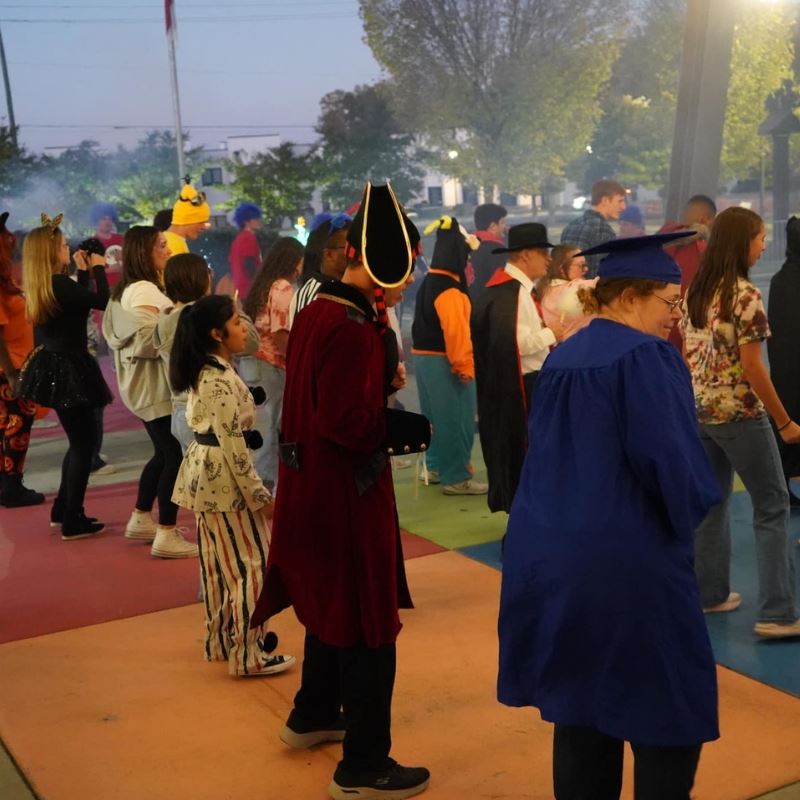 Group of individuals in costumes dance a t Boo Bash
