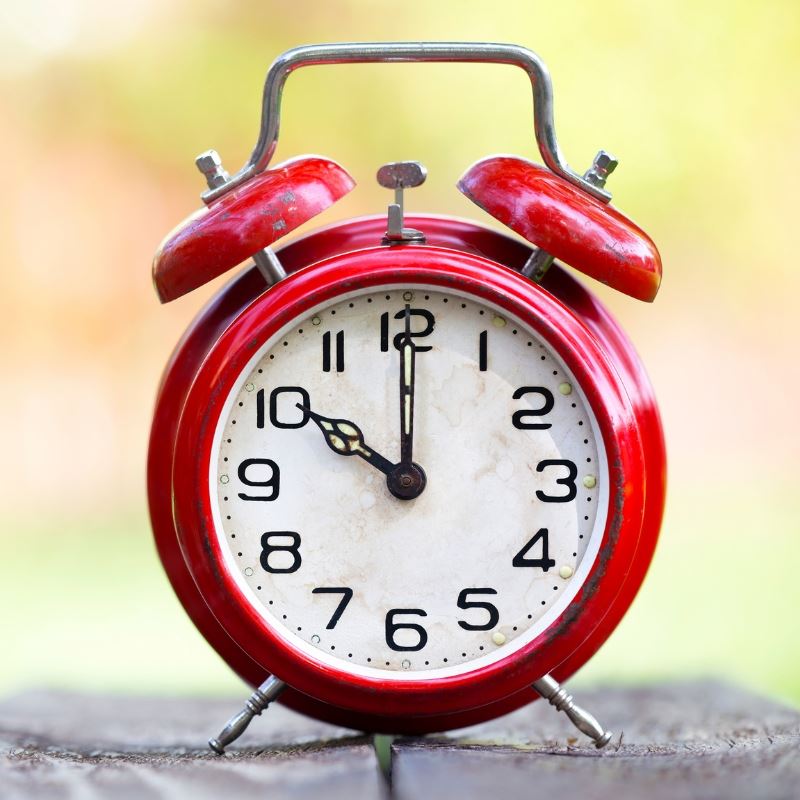 Red Alarm clock on table outside